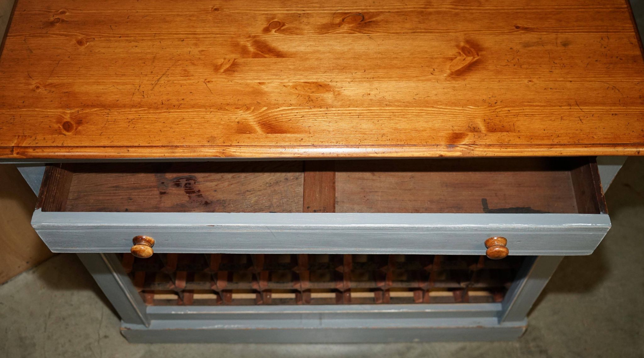 Vintage wooden furniture for 45 wine bottles with a drawer.