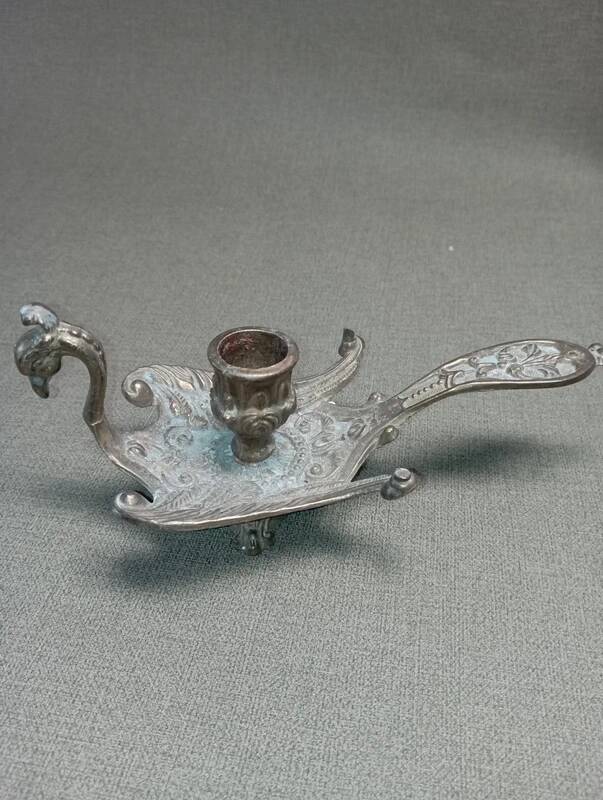 Chiselled brass candlestick in the shape of a peacock.