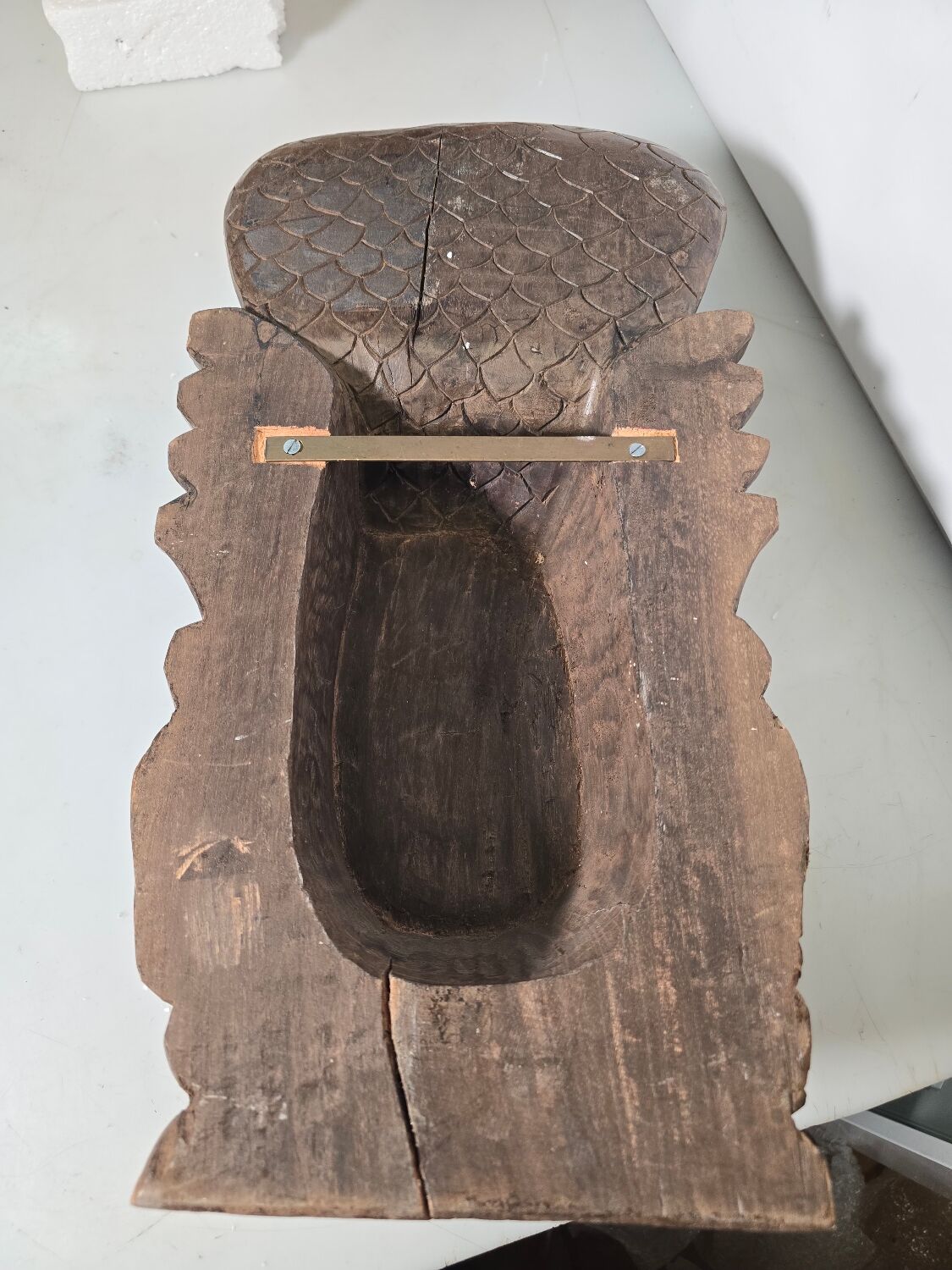 Ancient Indian carved wooden mask sculpture of a deity with a cobra.