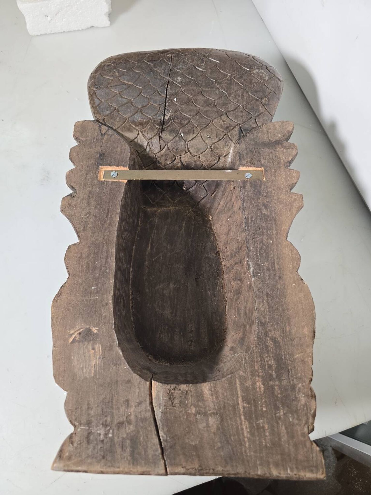 Ancient Indian carved wooden mask sculpture of a deity with a cobra.