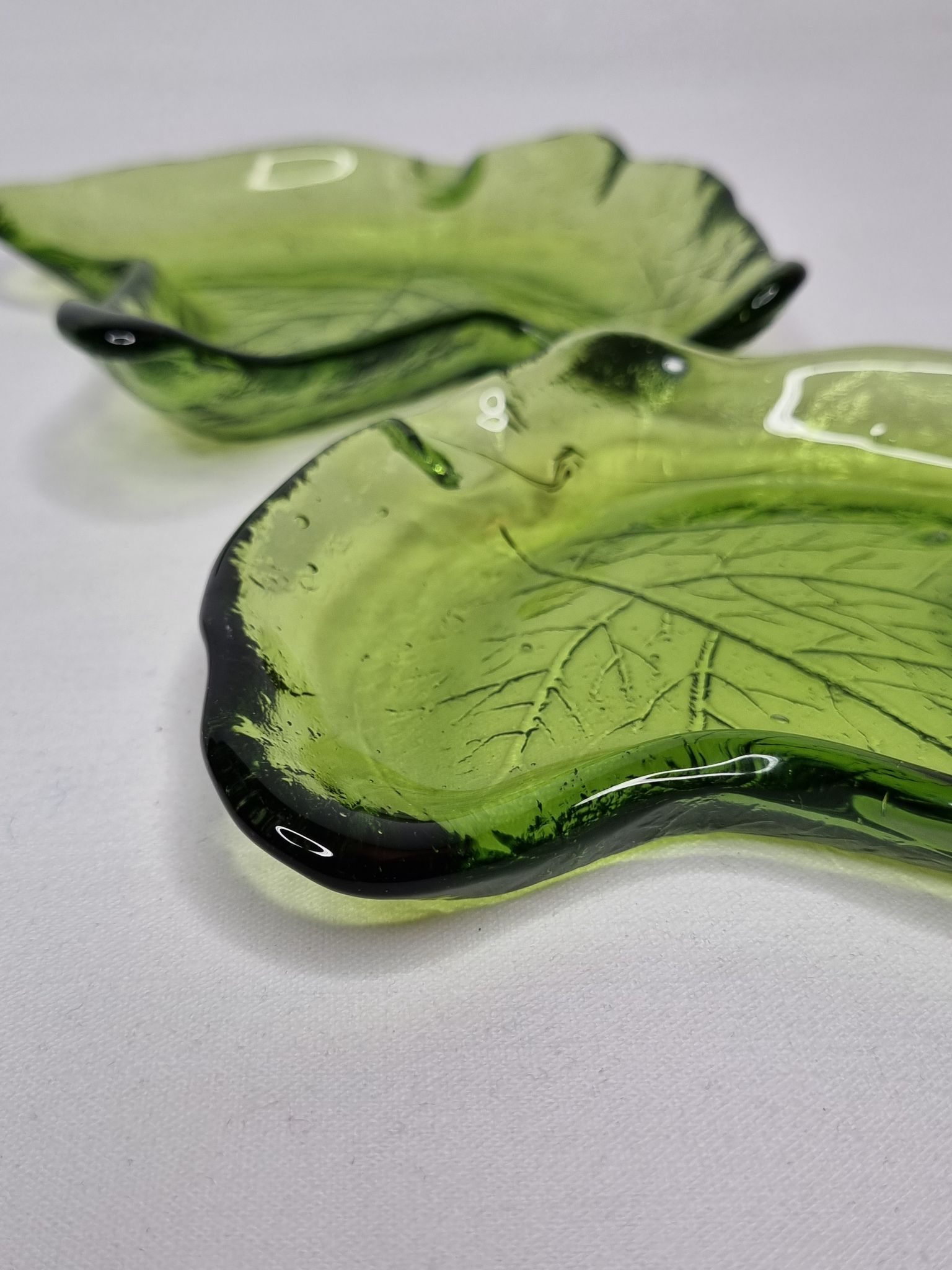 Deux vide poches en verre pressé en forme de feuilles de lierre, 17 cm
