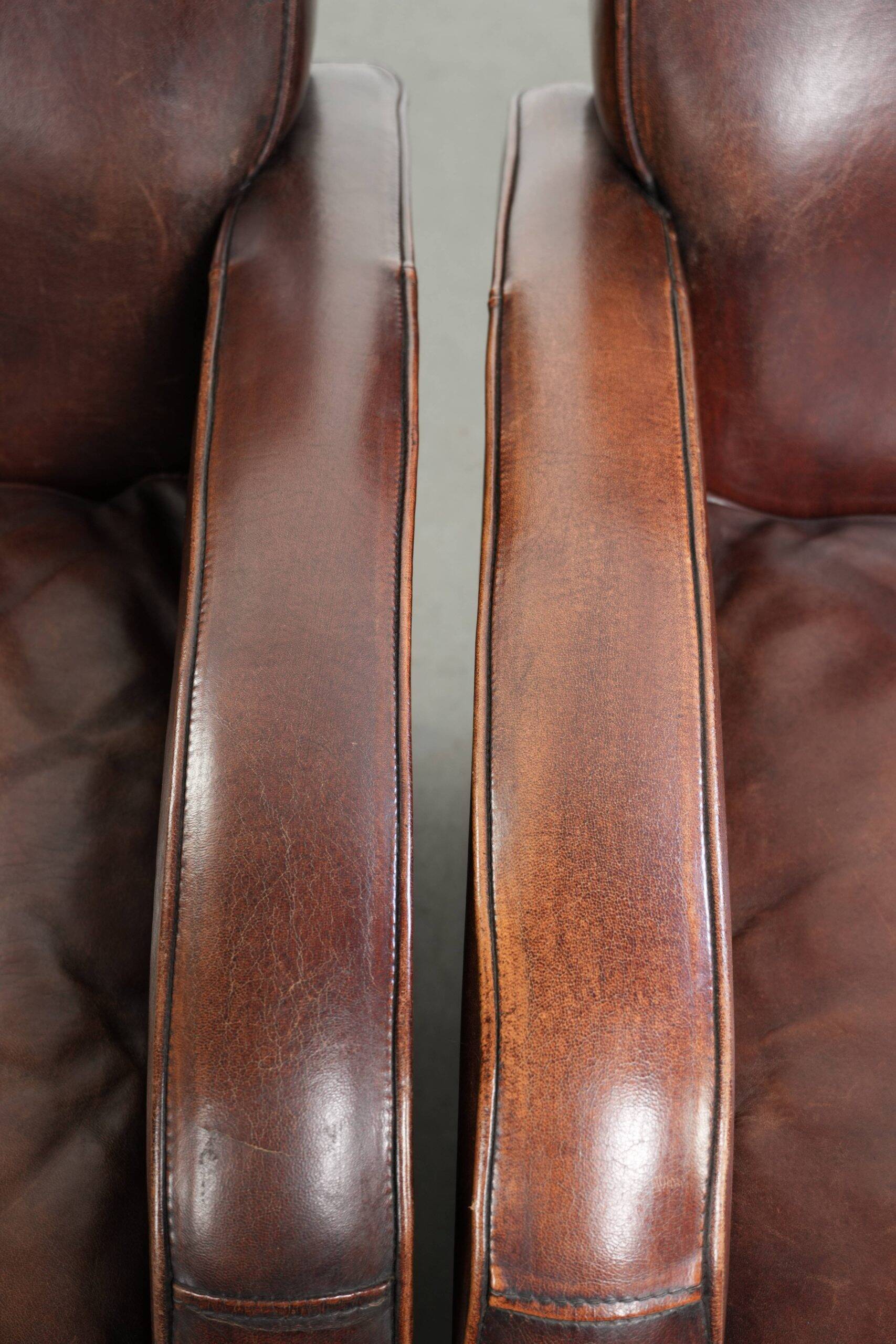 Dark cognac-coloured set of 2 sheepskin armchairs with a sleek design