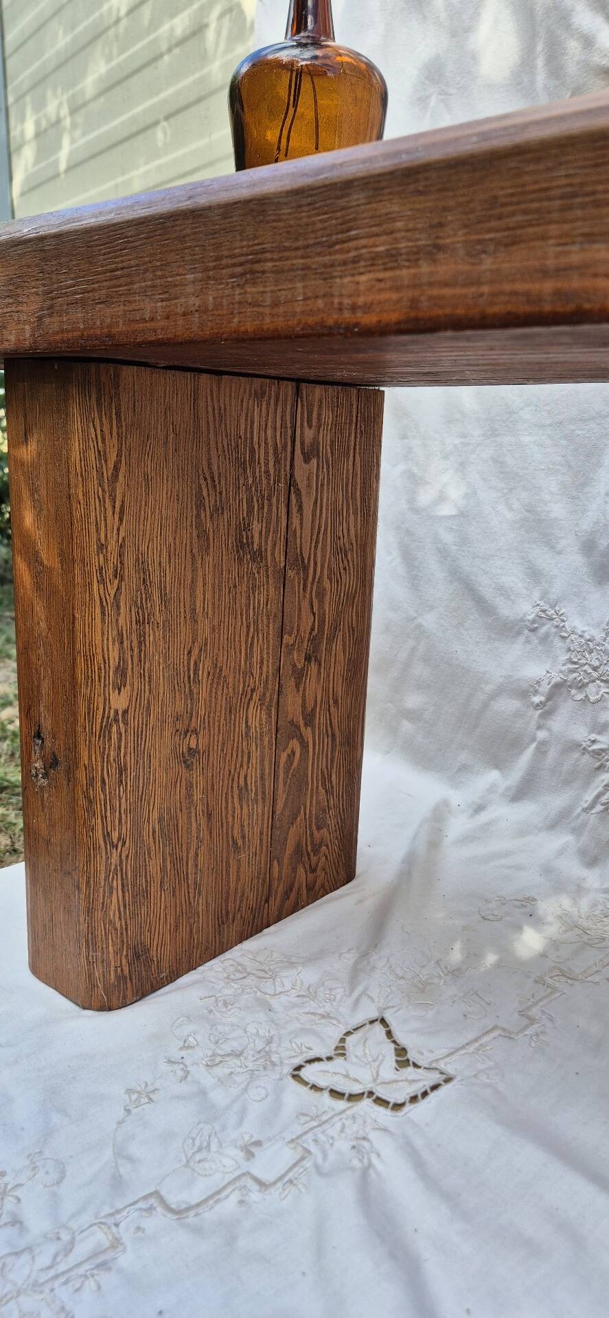 Brutalist wooden bench made of solid oak beam.