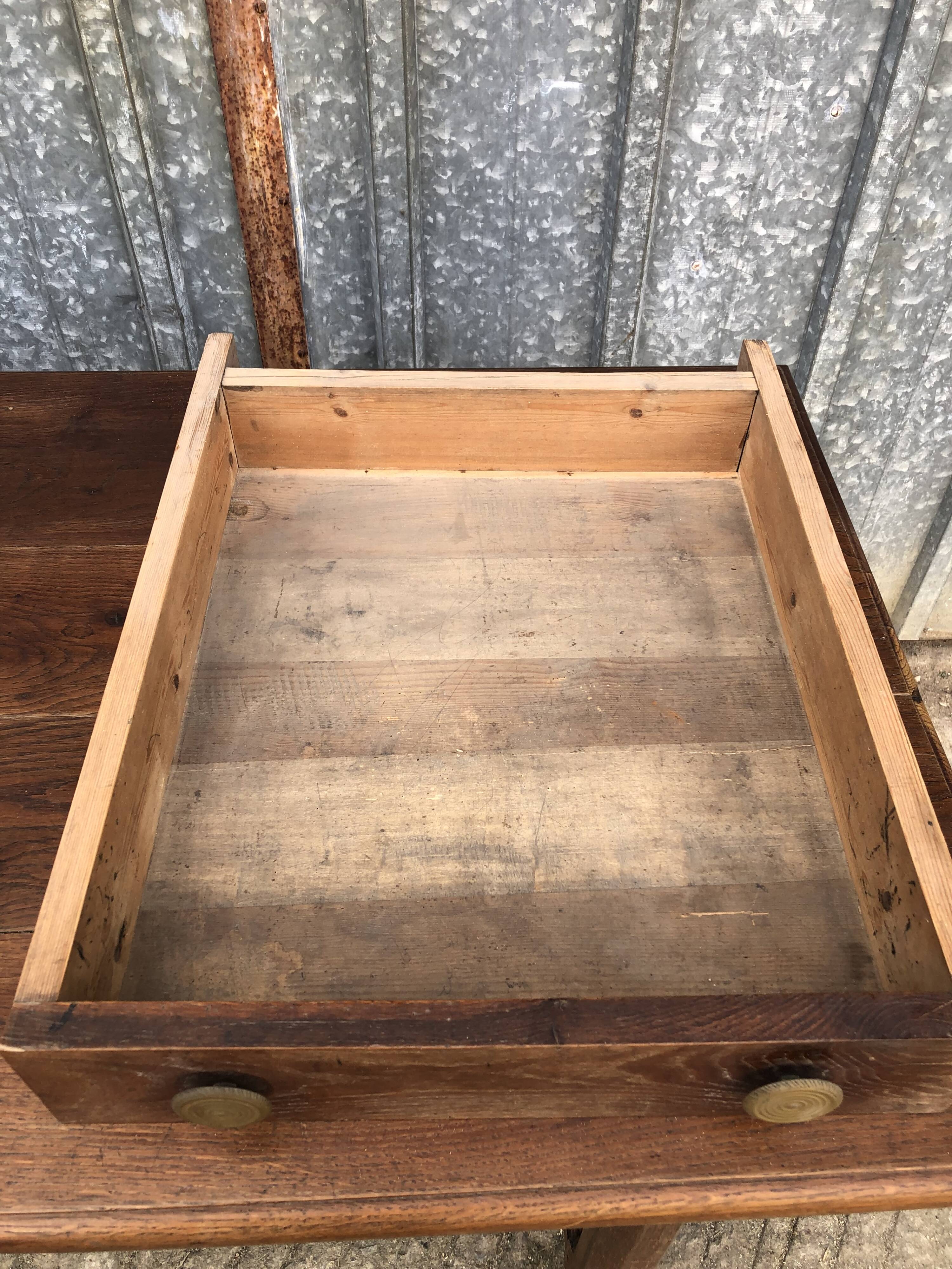 Table ancienne à barre à chat en chêne massif avec 2 tiroirs de face.