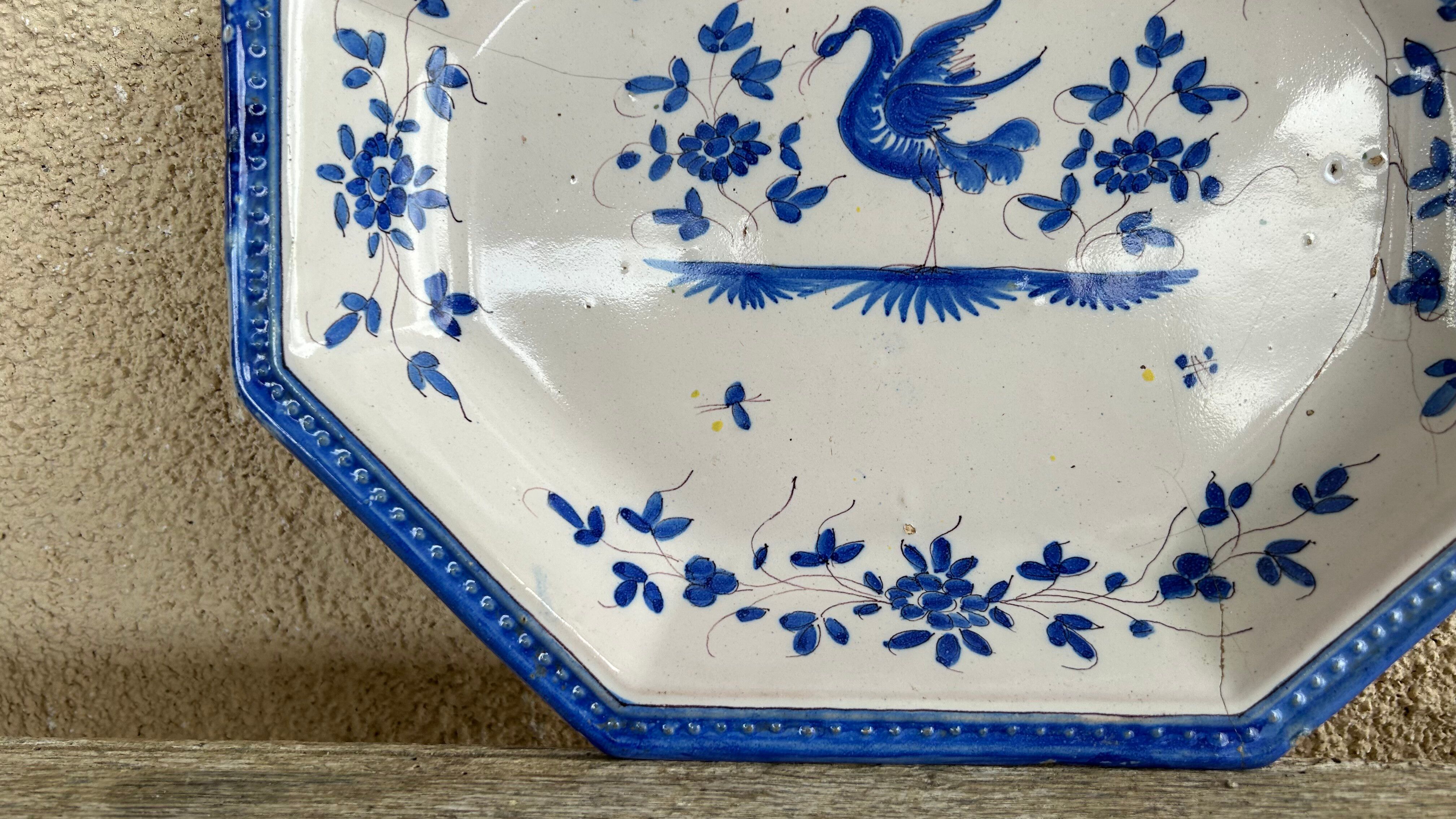 Antique octagonal plate in blue and white pottery with bird decoration.