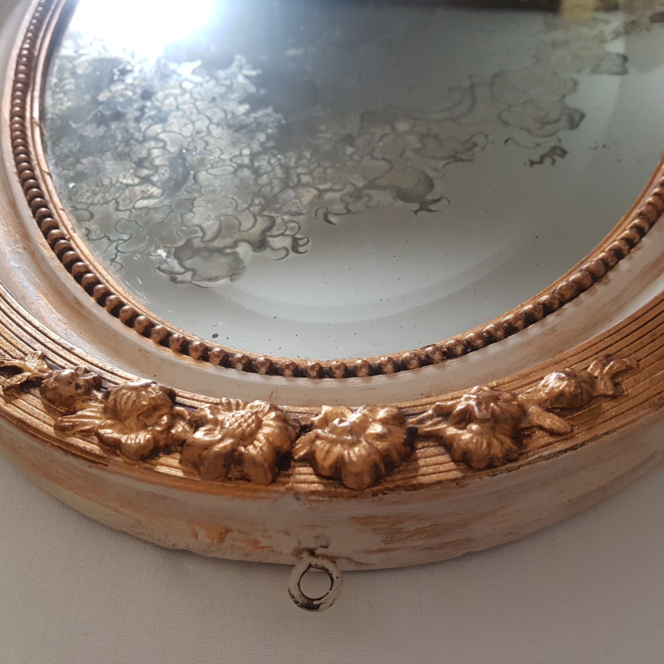 Large oval mirror with bevelled ice in stucque and wood decorated with flowers