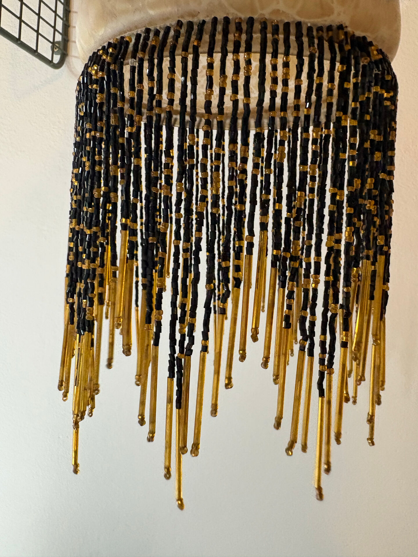 Wall lamp with marbled glass shade and beaded fringe in Art Nouveau style.