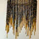 Wall lamp with marbled glass shade and beaded fringe in Art Nouveau style.