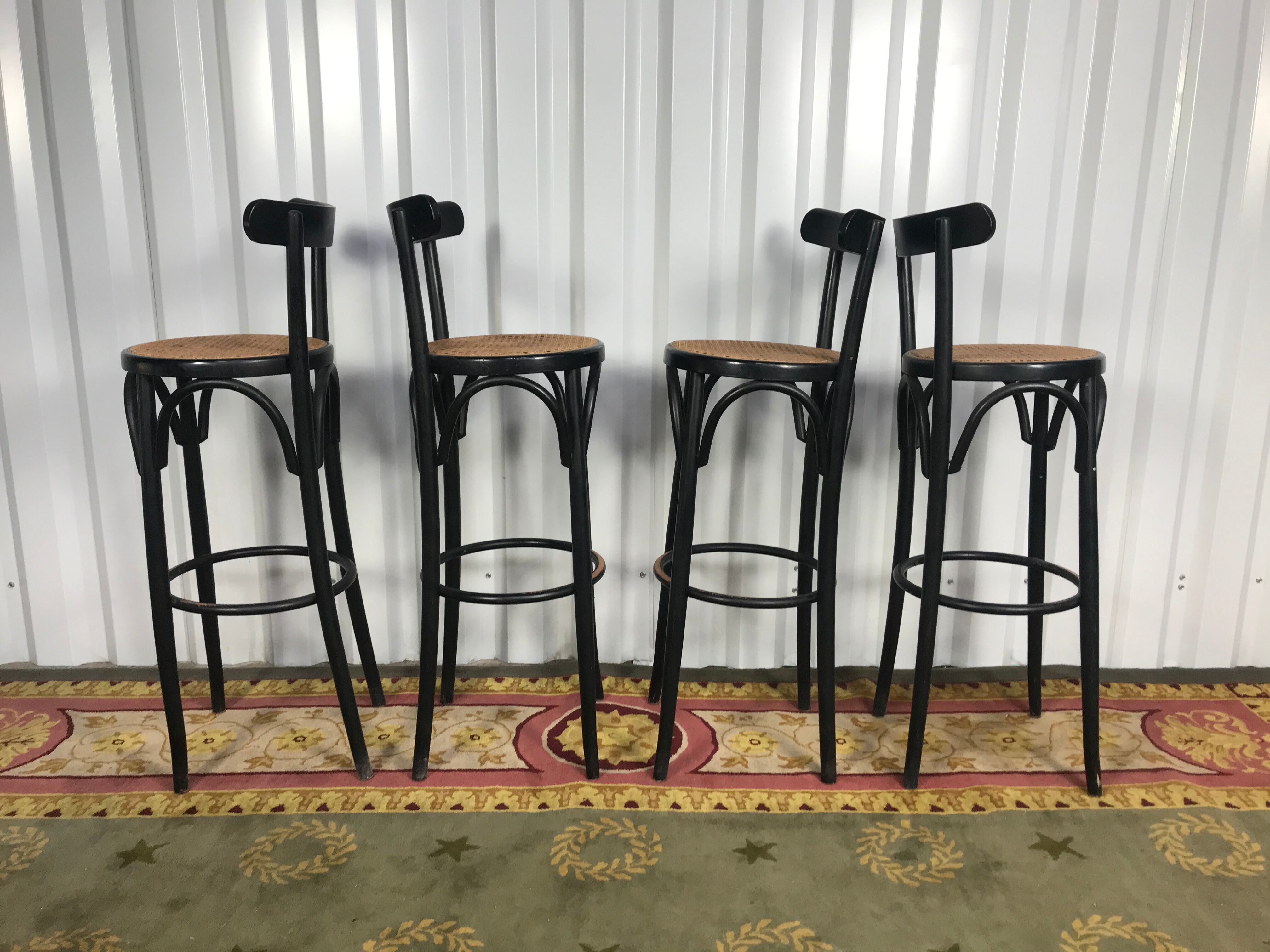 Suite de 4 tabourets de bar en cannage et bois noirci