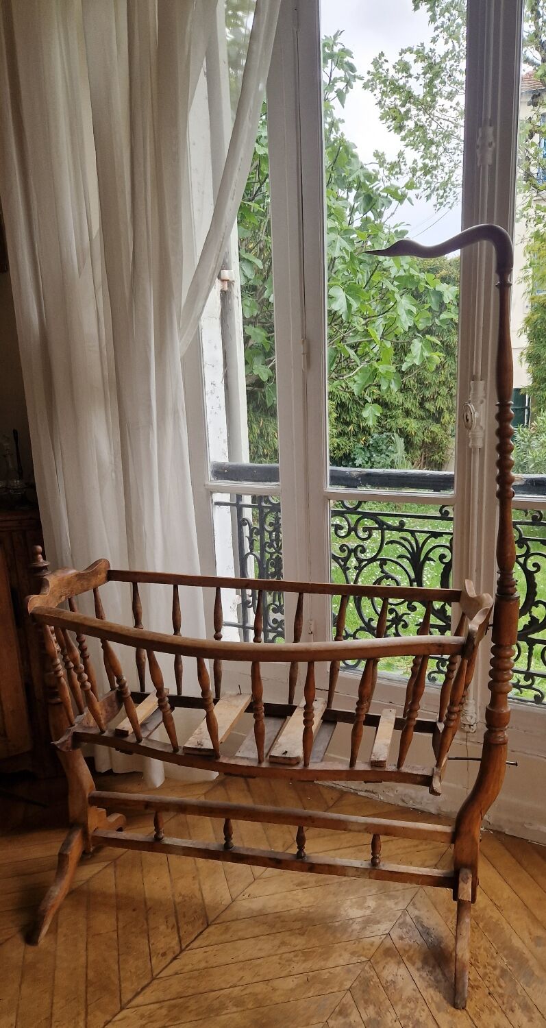 Wooden cradle in walnut with a sign collar at the top.