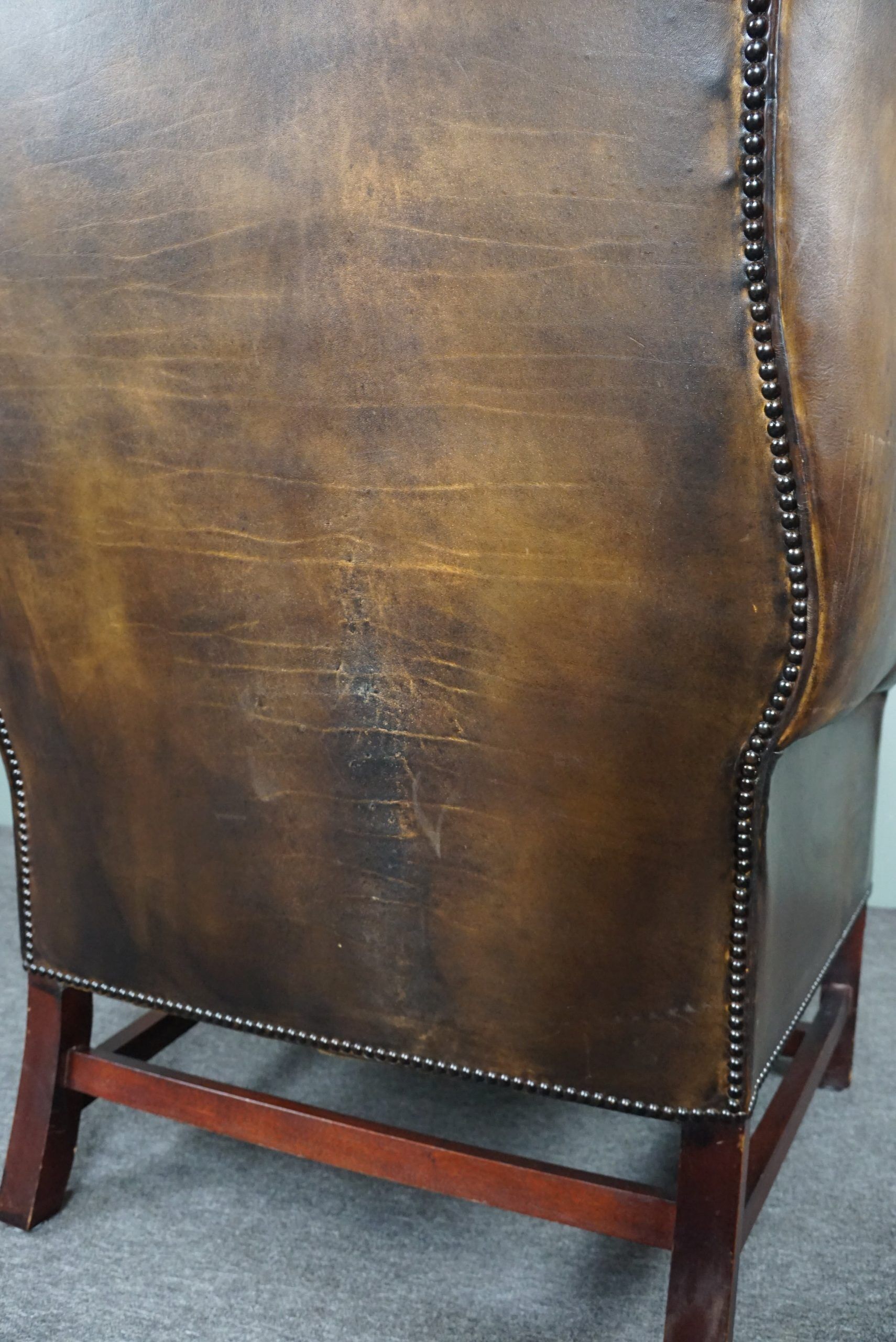 Patinated cowhide leather armchair