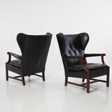 Pairs of black leather Scandinavian armchairs