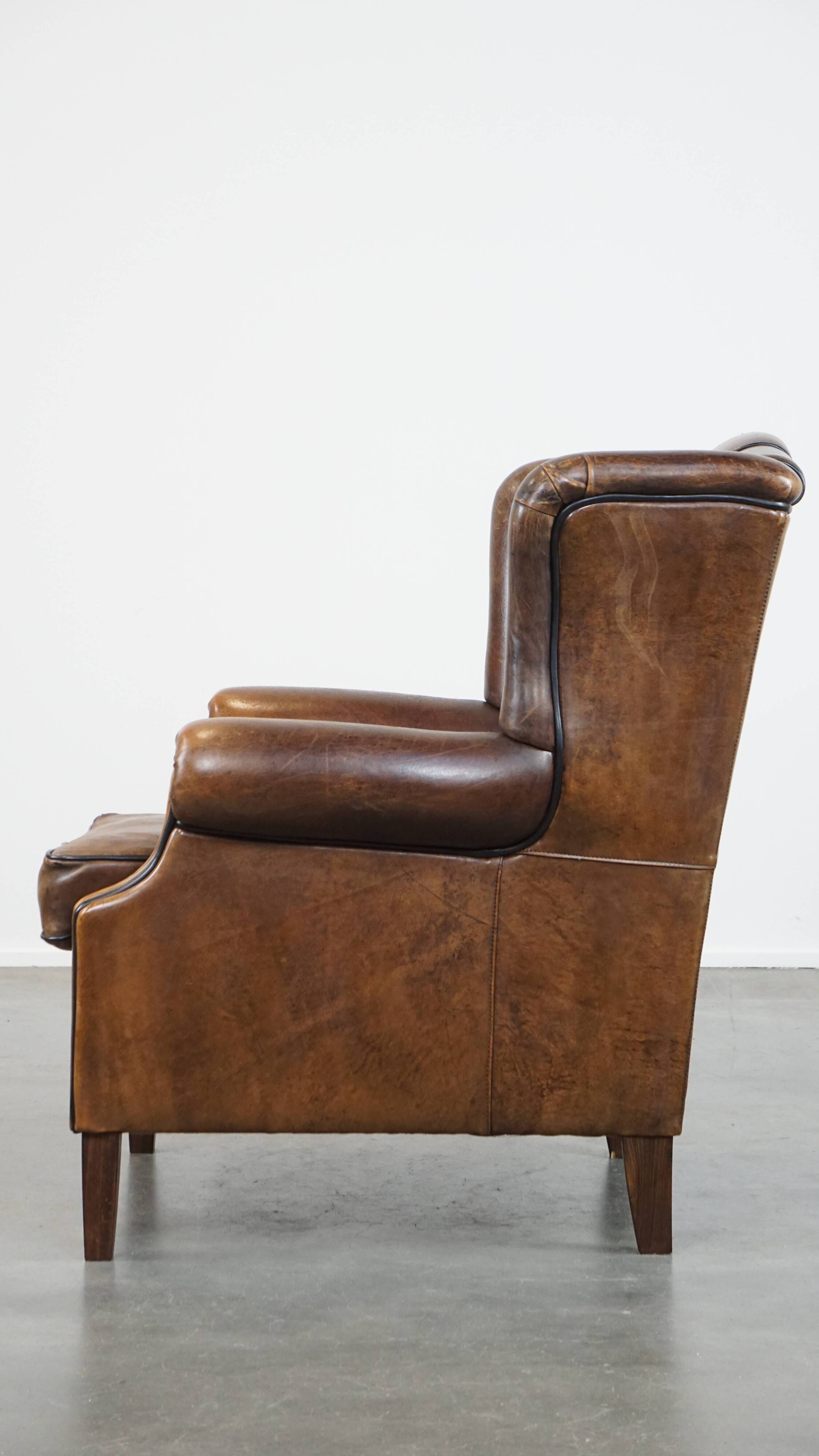 Vintage sheepskin wingback chair finished with black piping