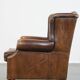 Vintage sheepskin wingback chair finished with black piping