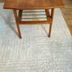 Scandinavian coffee table in teak with a lower shelf and brass bars.