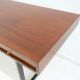 Wooden desk with drawers and black lacquered legs.