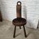 Antique tripod chair in solid wood and animal skin.