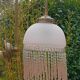 Brass swan neck wall lamp with pink glass globe and Charleston tassels