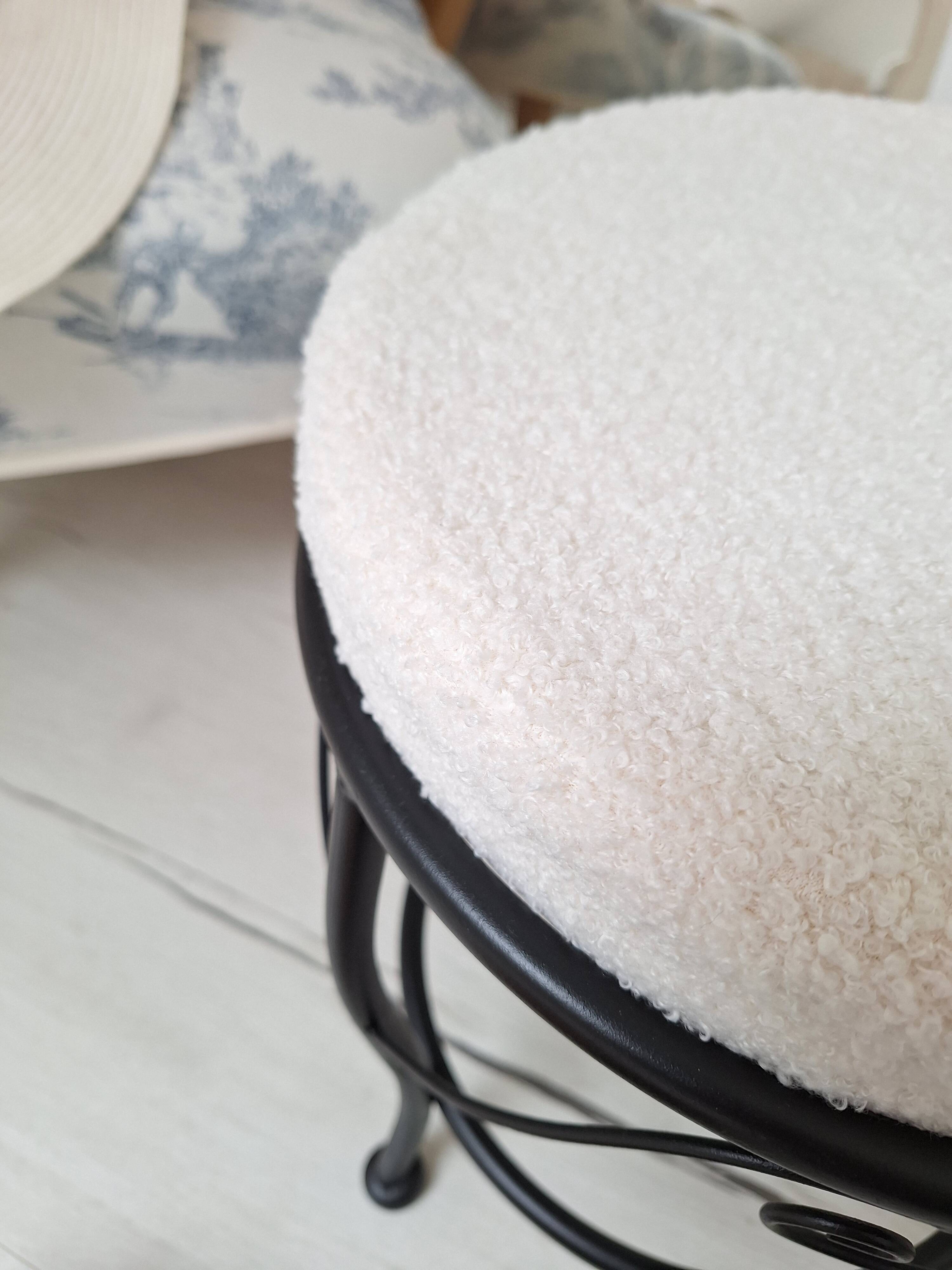 Black iron stool/pouf with its boucle fabric cushion.