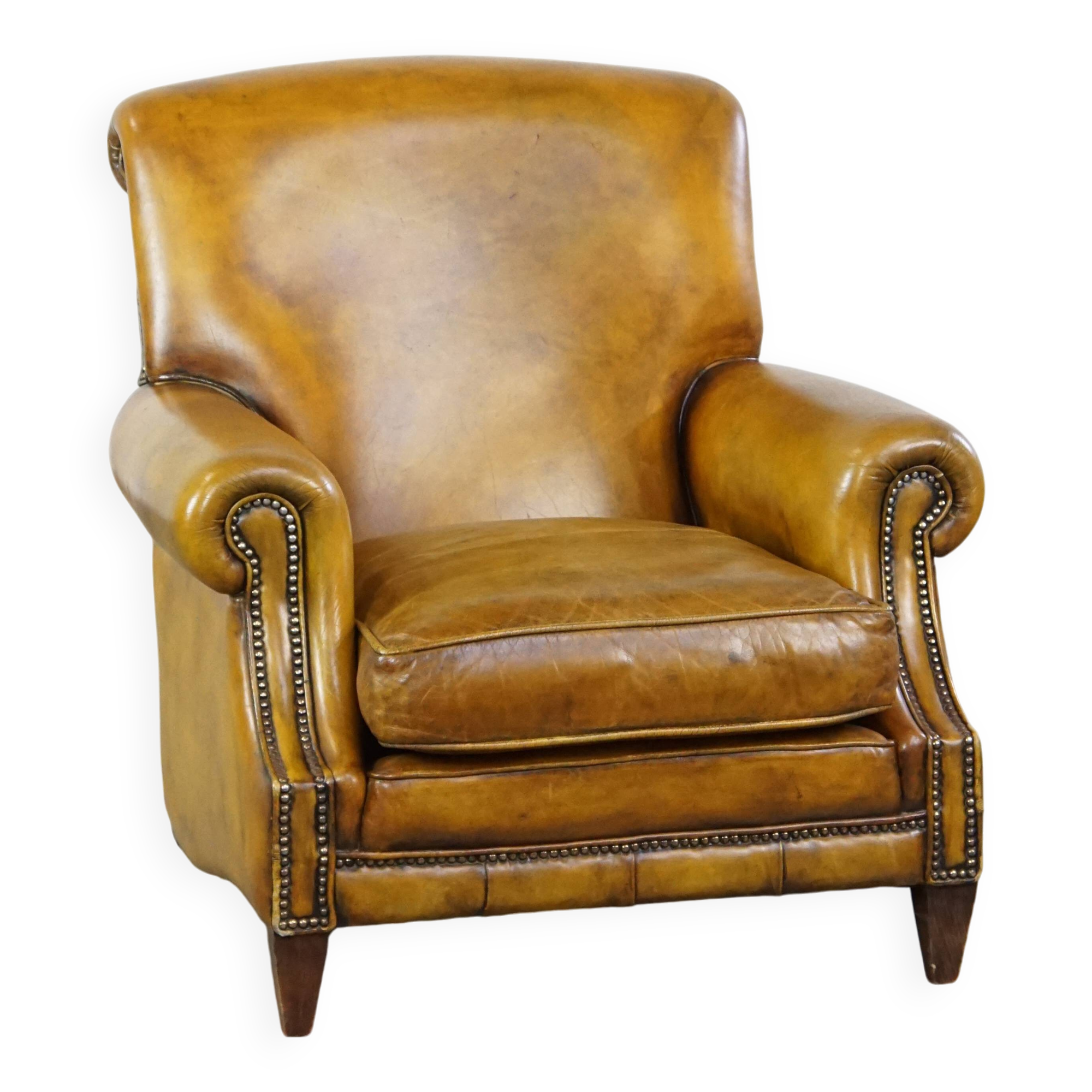 Comfortable large yellow English-style leather armchair with a fine finish and decorative nails