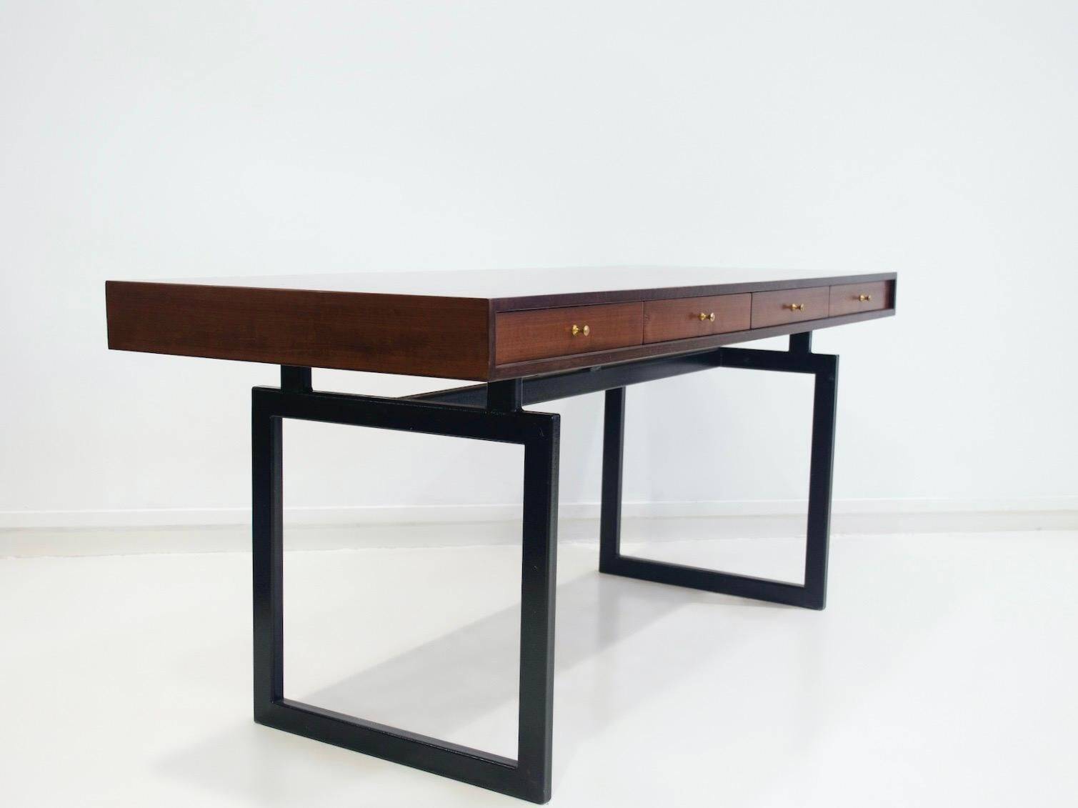 Wooden desk with drawers and black lacquered legs.