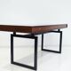 Wooden desk with drawers and black lacquered legs.