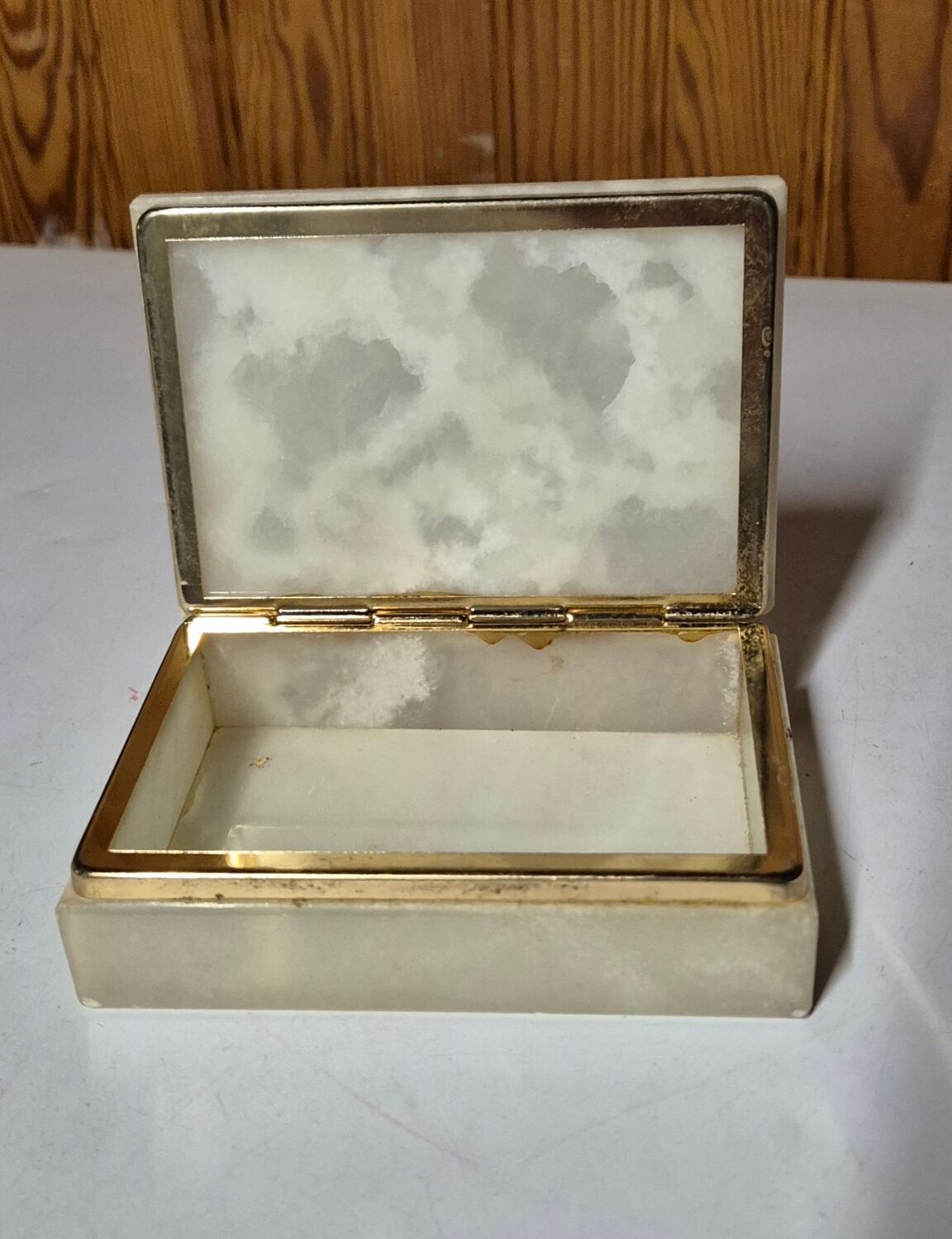 Rectangular light onyx jewellery box with brass trim, empty.