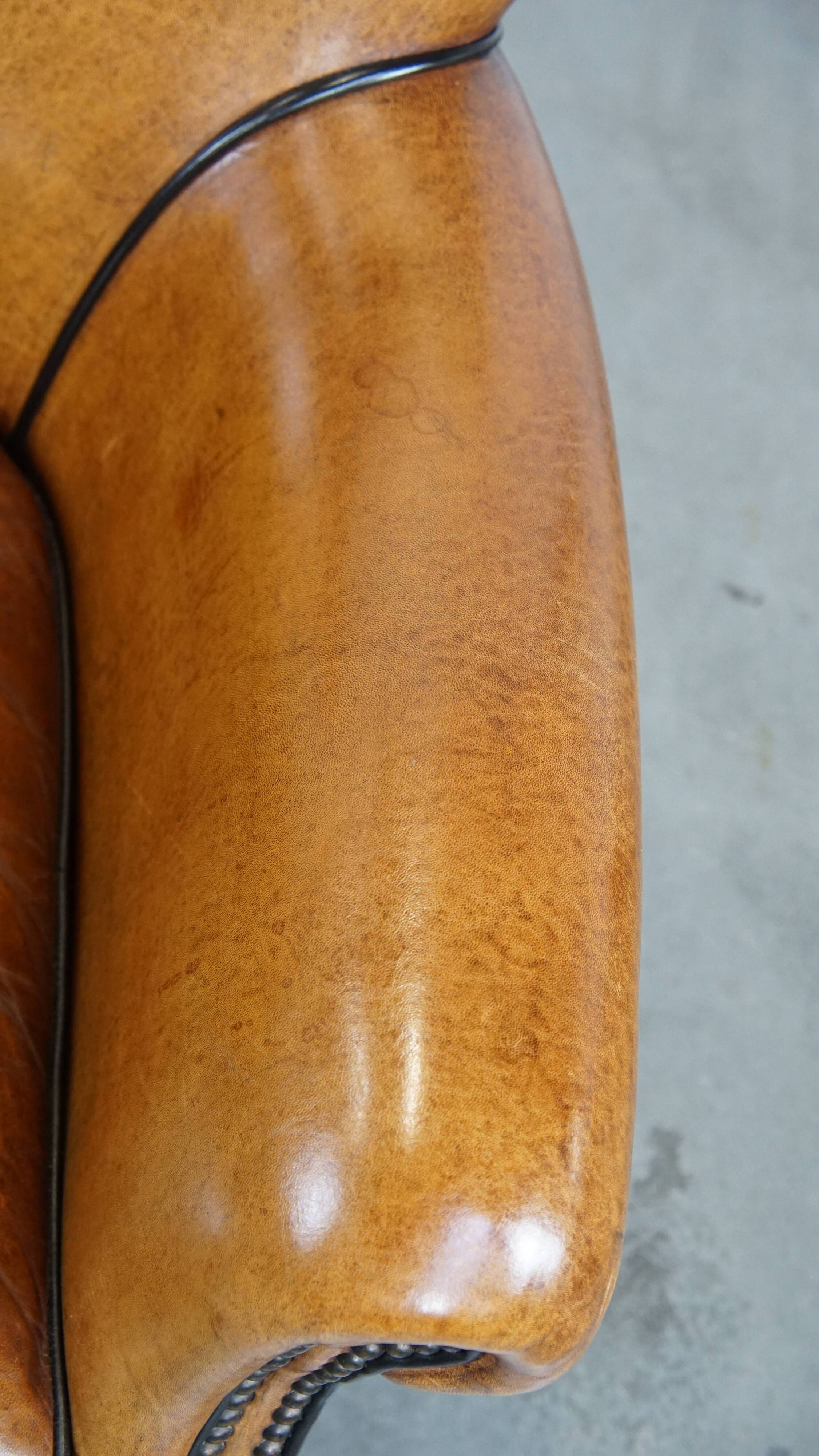 Cognac-colored sheep leather armchair finished with decorative nails
