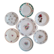 7 mismatched antique dessert plates accompanied by a pie dish