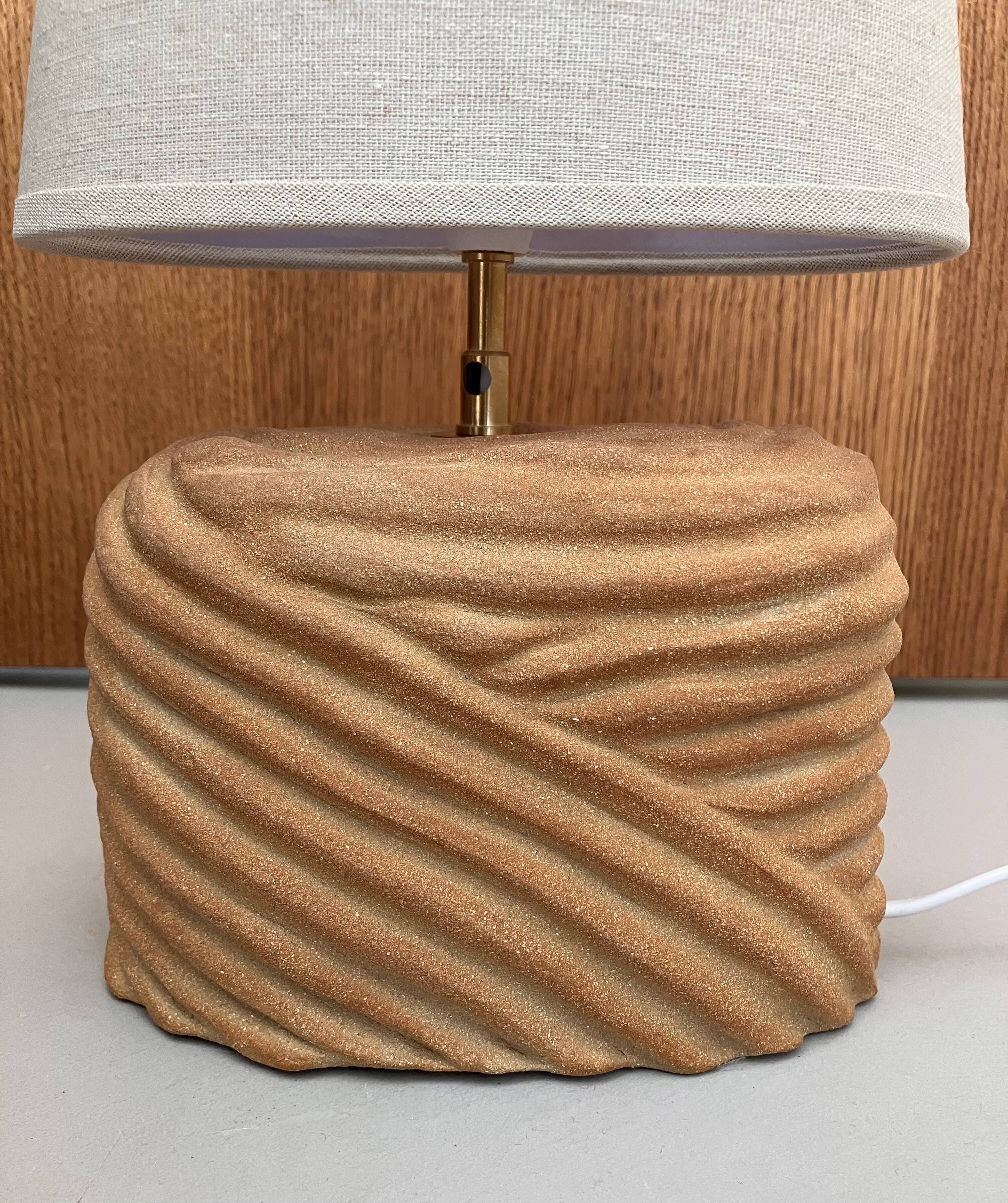 Oval table lamp in handcrafted ceramic with draped effect.