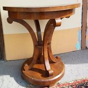 Art Deco side table in brown walnut, round top and scroll legs, France 1930s.