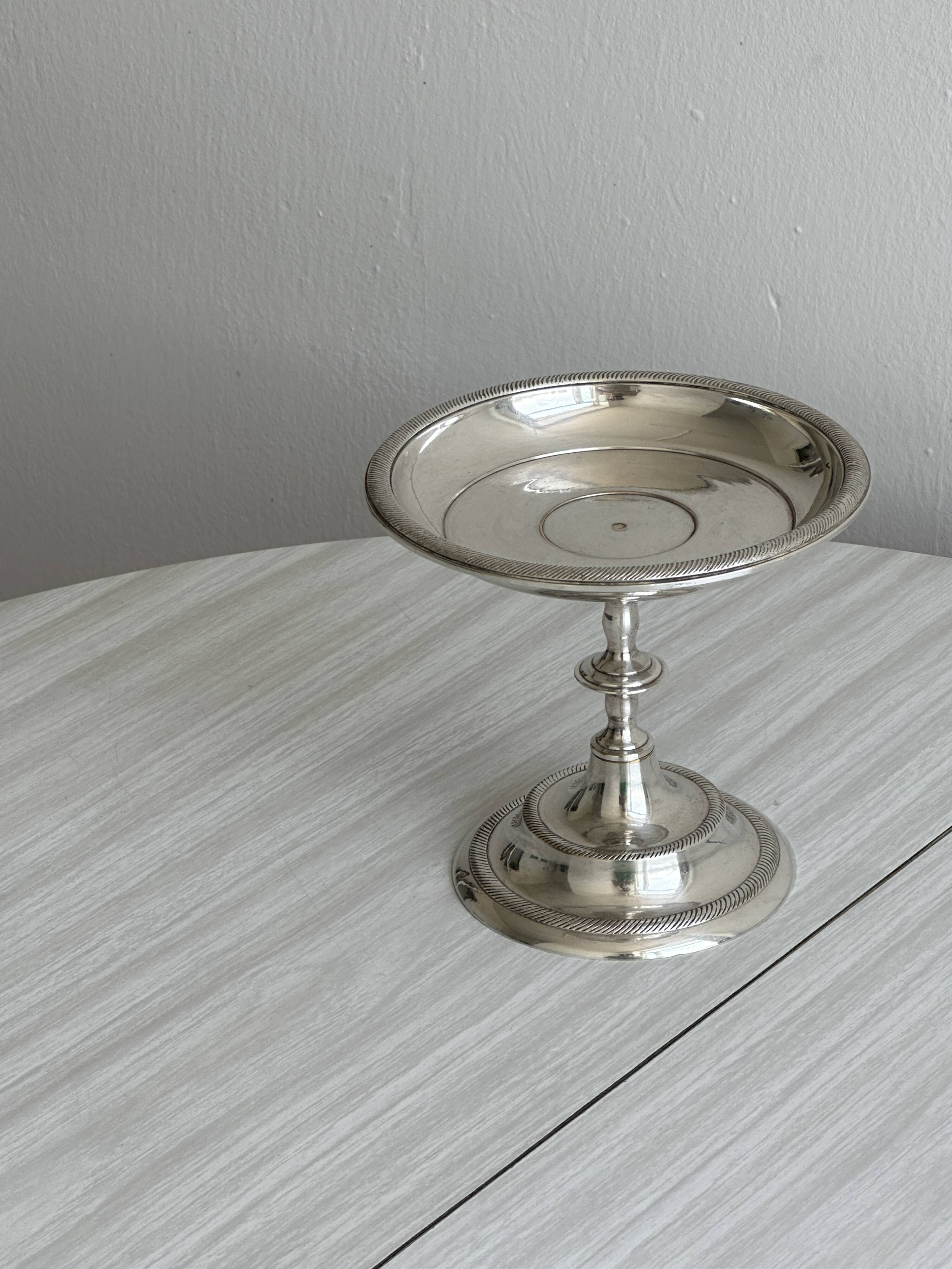 Silver-plated metal stand.