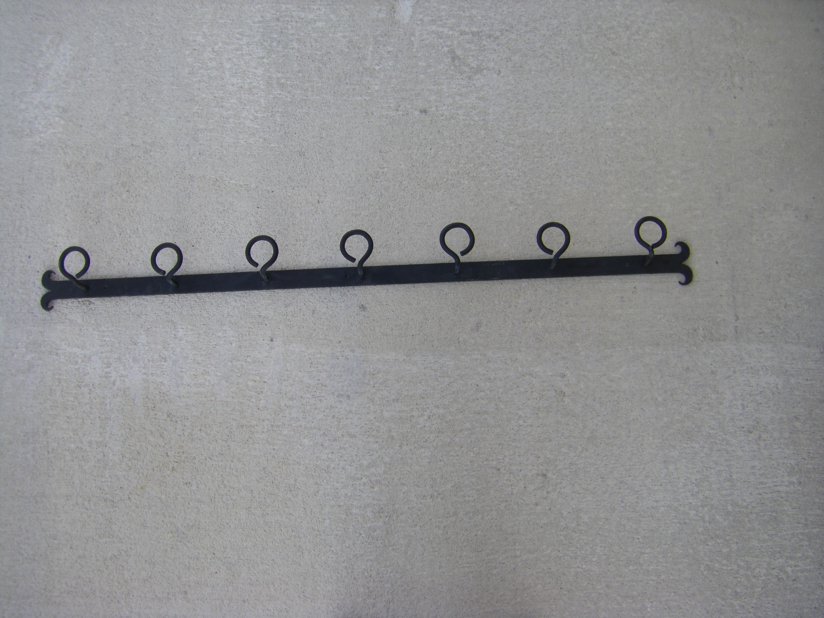 Wall-mounted wrought iron coat racks.