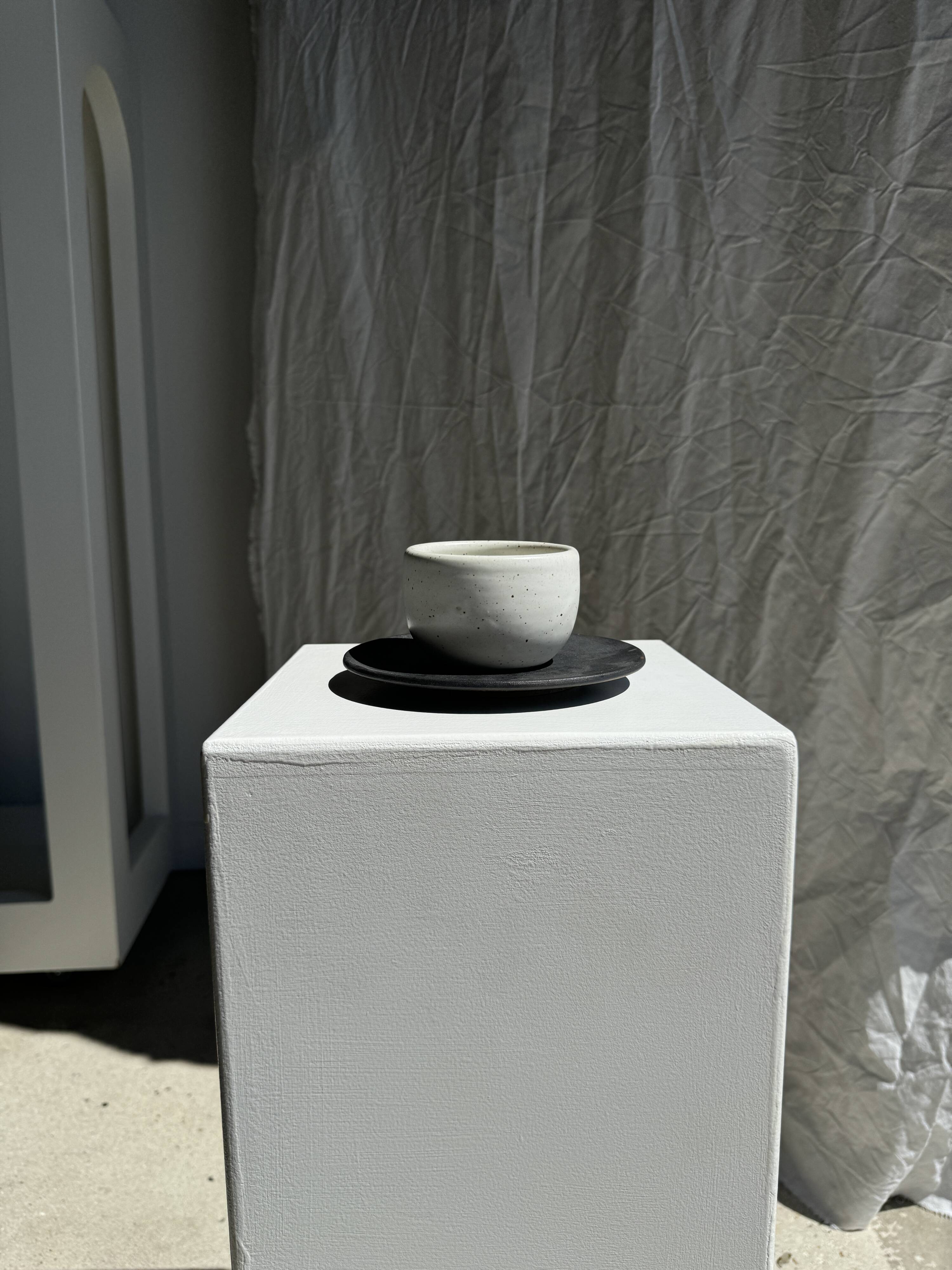 White Indonesian ceramic cup and gray saucer