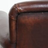 Sheepskin armchair with a classic finish and decorative studs.