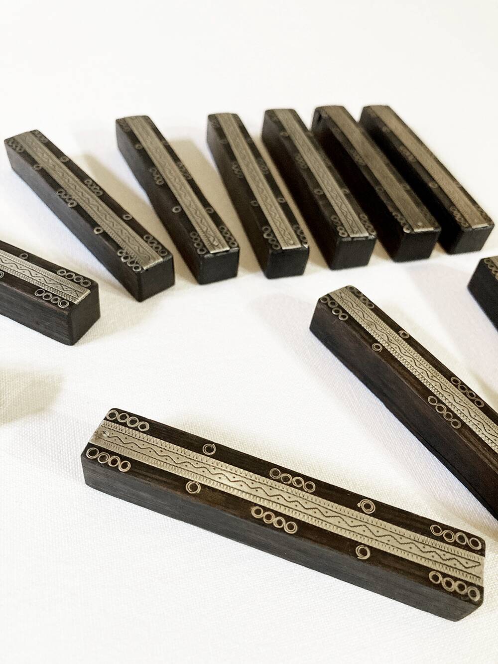 Set of 11 ebony wood knife rests with brass inlay