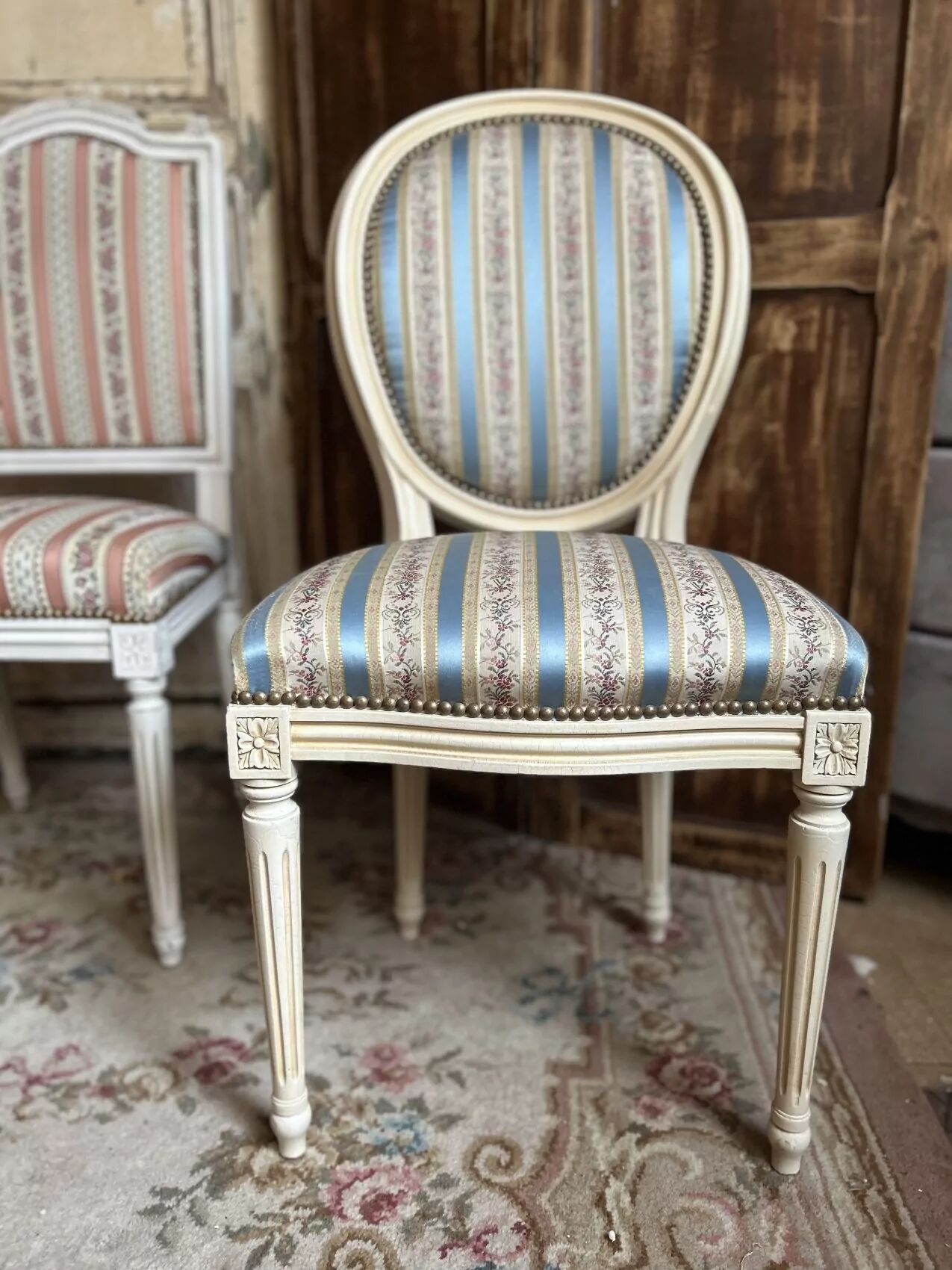 Pair of Louis XVI style chairs in painted wood and satin, classic elegance.