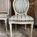 Pair of Louis XVI style chairs in painted wood and satin, classic elegance.