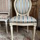 Pair of Louis XVI style chairs in painted wood and satin, classic elegance.
