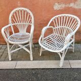 Two white rattan armchairs
