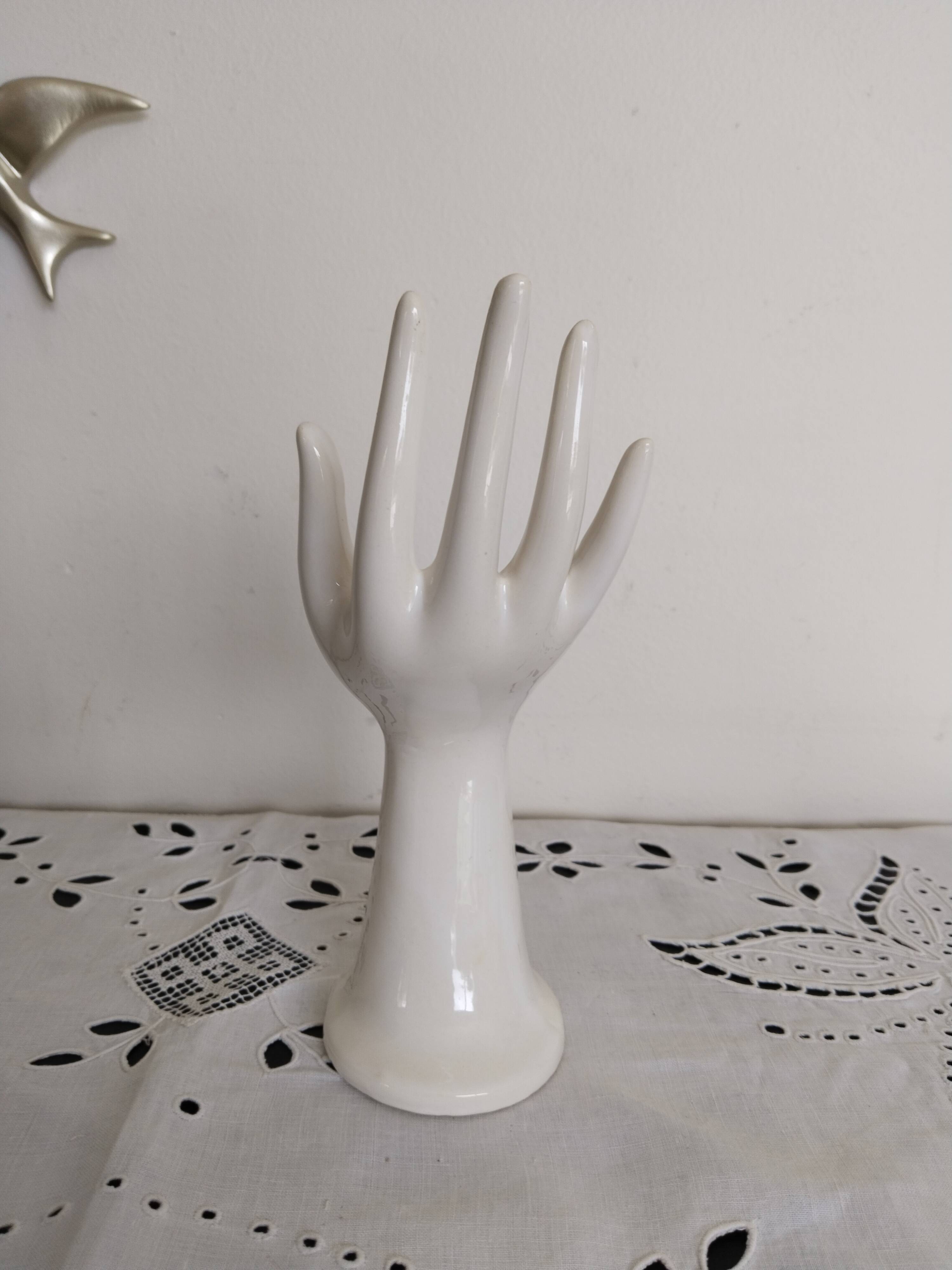 Hand holds white jewelry, ring sizer