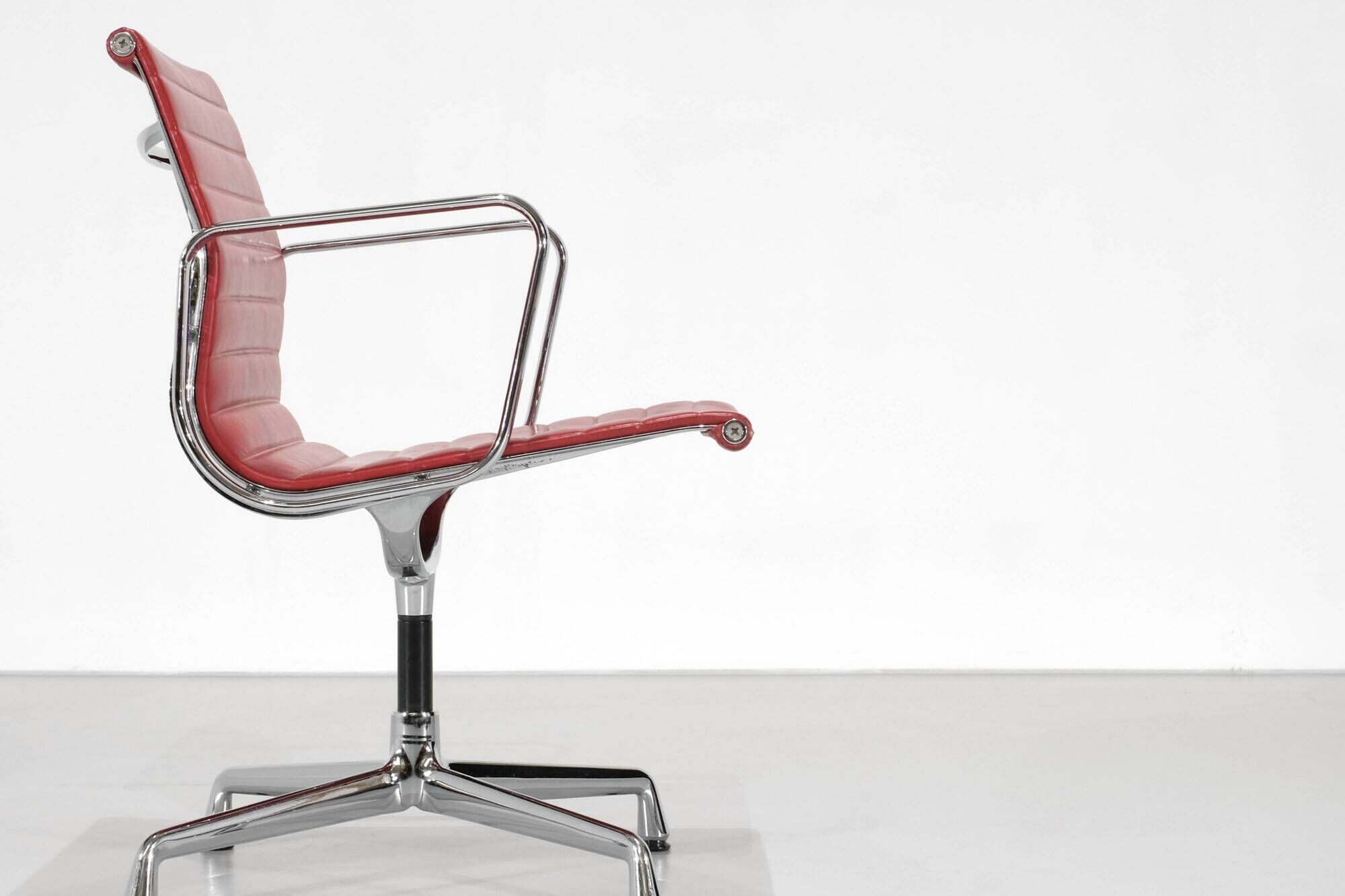 "EA 108" armchair in red leather, designed by Charles and Ray Eames for Vitra,