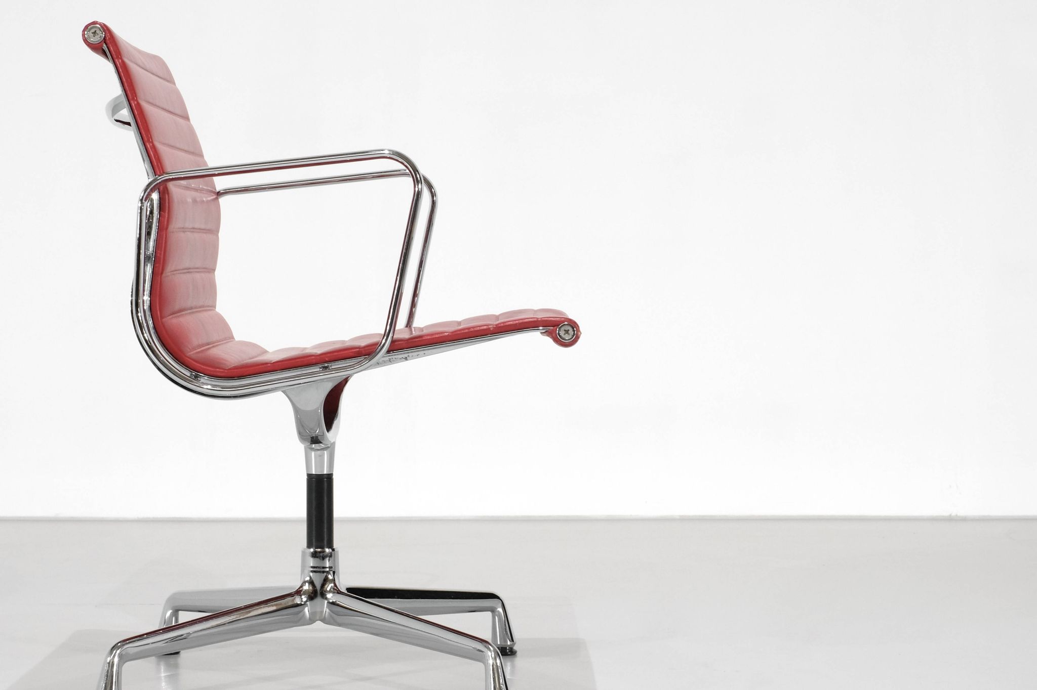 Fauteuil " EA 108 " en cuir rouge, conçu par Charles Ray Eames pour Vitra,
