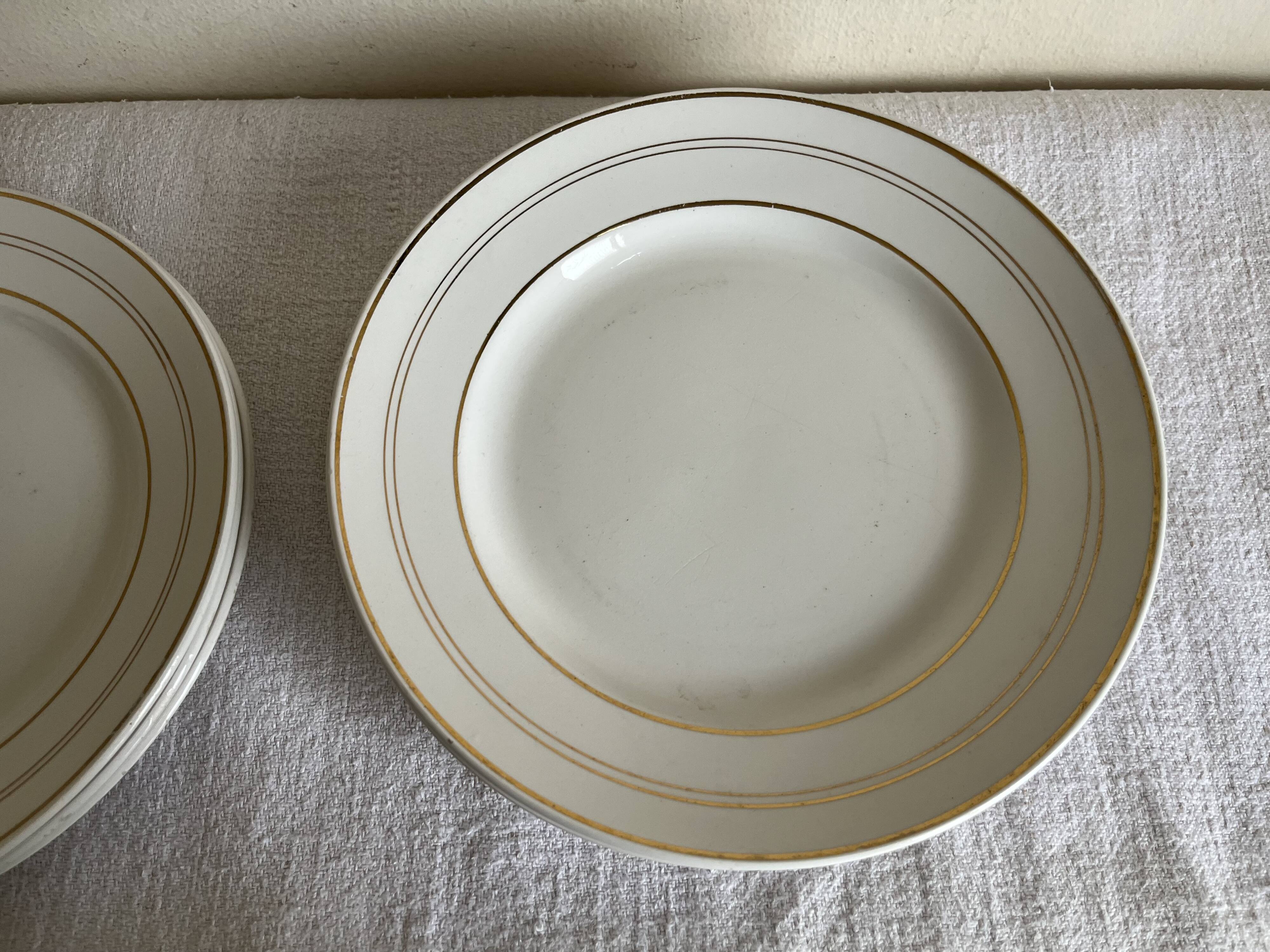 Set of 8 modernist flat plates in fine earthenware with pure gold trim, 1930.