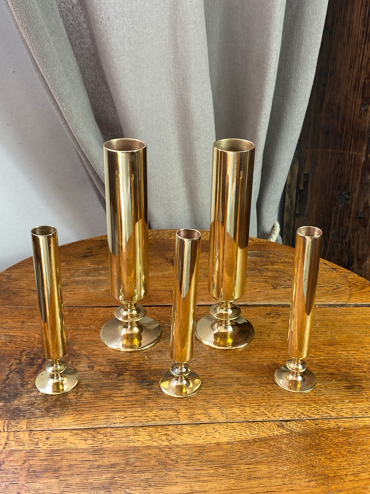 Set of candlesticks and tubular vases in solid brass.