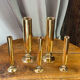 Set of candlesticks and tubular vases in solid brass.