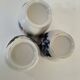 Set of three hand-painted porcelain cups with floral patterns.