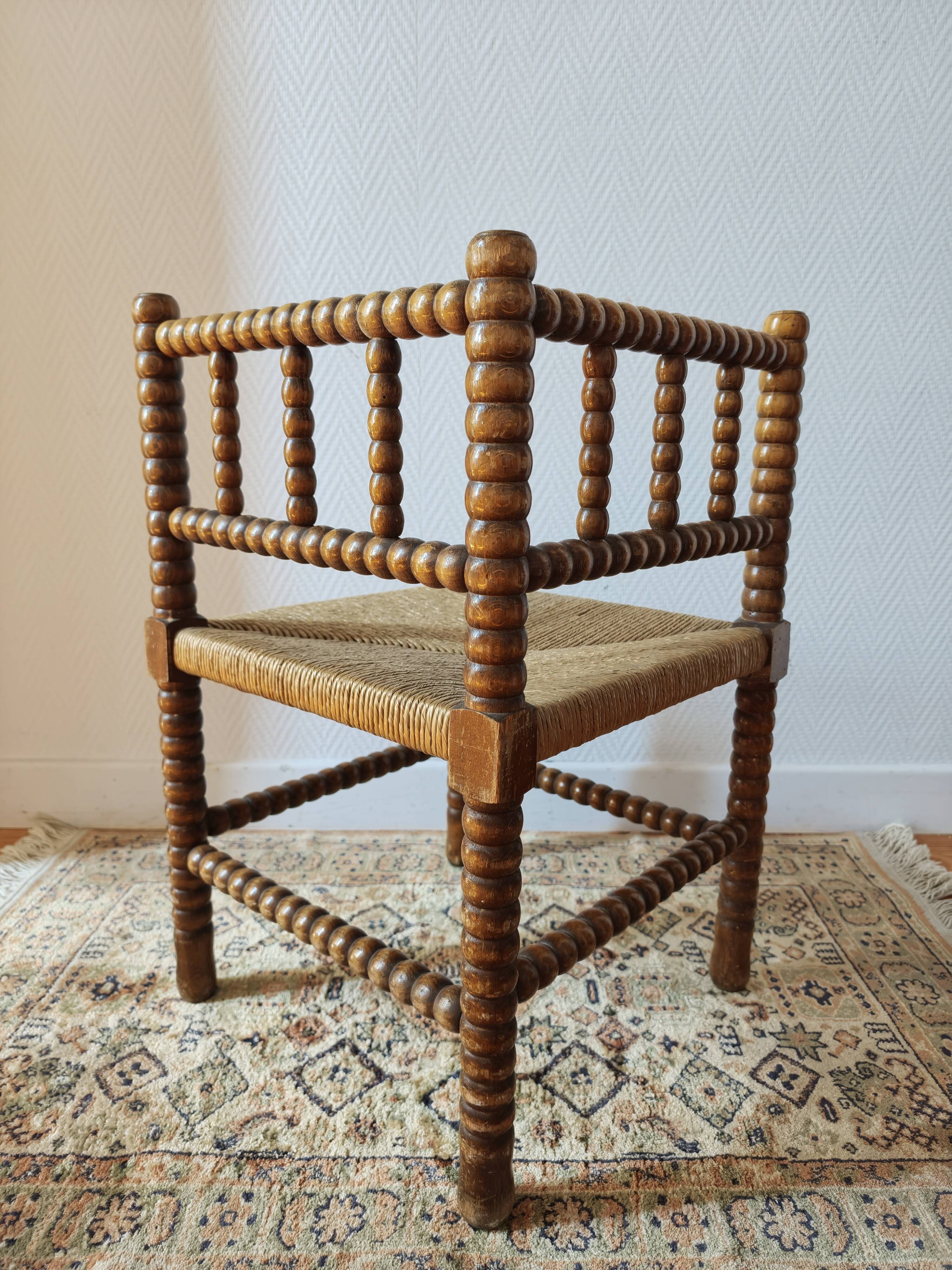 Antique corner chair by the fire with turned wood and straw seat.