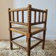 Antique corner chair by the fire with turned wood and straw seat.