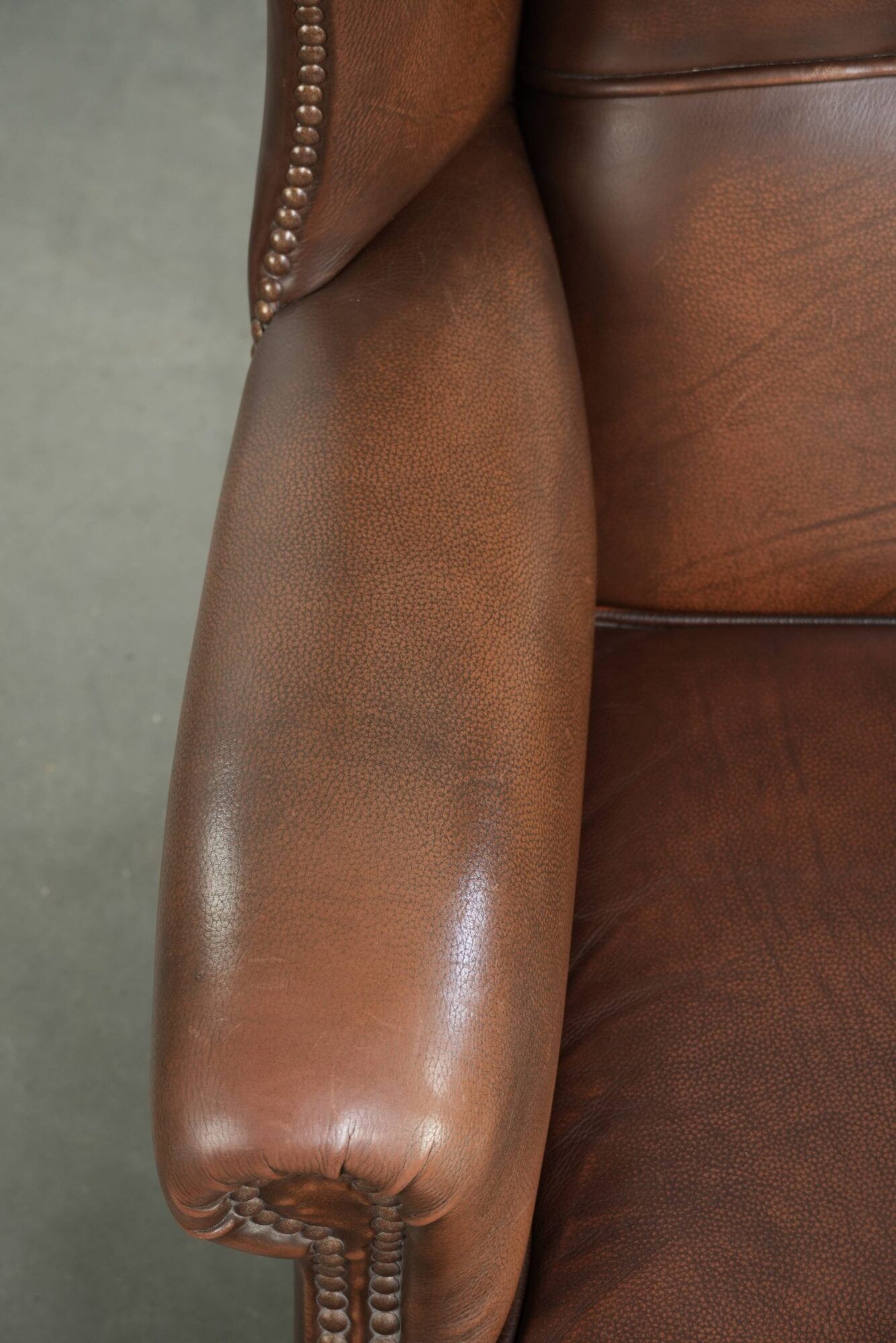 Cowhide wingback armchair in English style finished with decorative nails